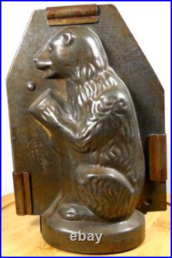 Antique vintage German metal chocolate mold with clamps sitting bear on tree trunk